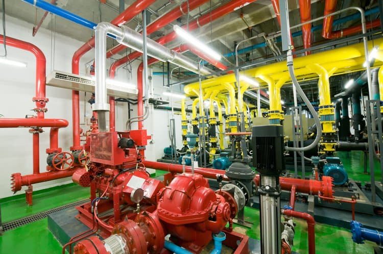 Another mechanical room featuring red and yellow painted pipes, creating a colorful and well-maintained appearance.