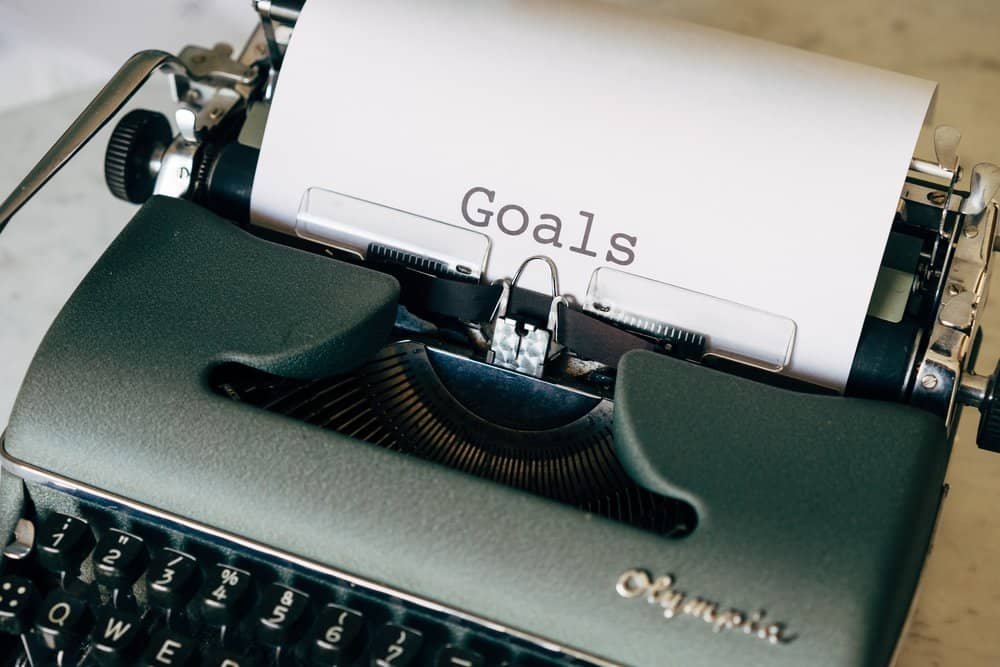 A vintage typewriter with a piece of paper that has the word “Goals” typed on it.