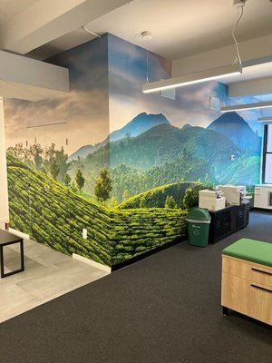 Office space with a large wall mural of a lush green mountain landscape, enhancing the room with a vibrant and refreshing outdoor feel.
